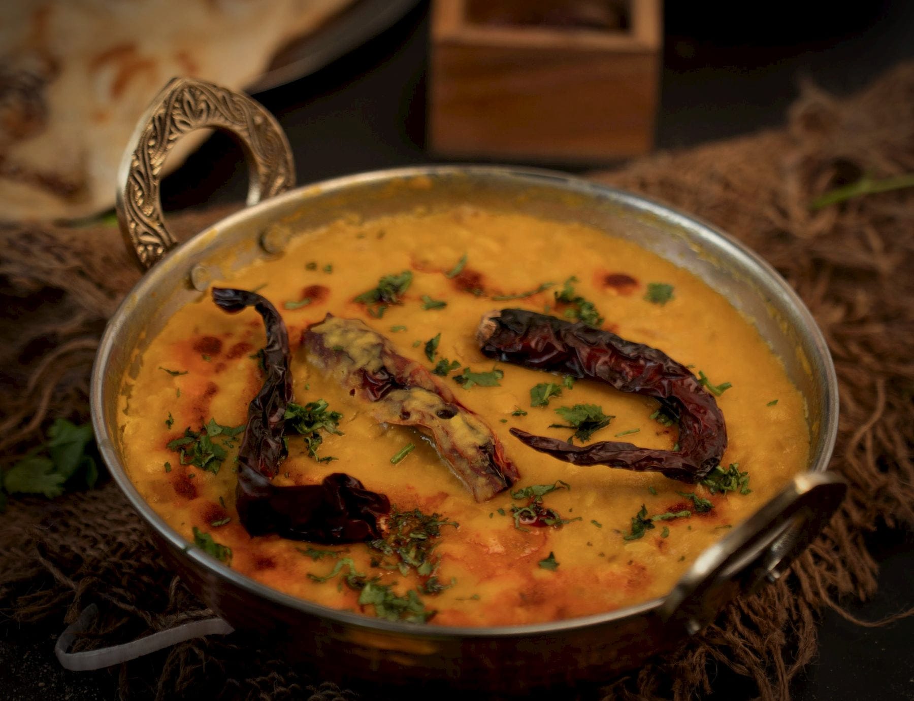 Yellow dal with a tempering of whole dried red chillies in a brass-handled kadai